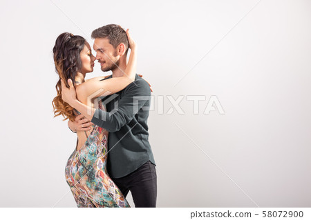 Skillful dancers performing in the white background with copy space. Sensual couple performing an Skillful dancers performing in the white background with copy space. Sensual couple performing an 58072900