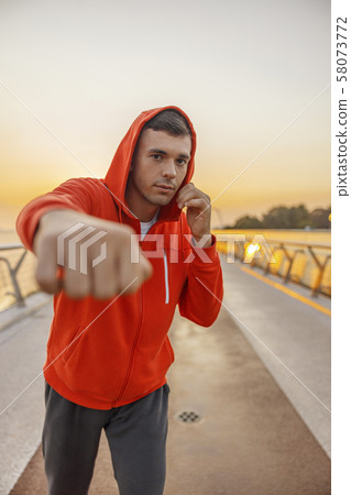 Serious fit young man working out outdoors Serious fit young man working out outdoors 58073772