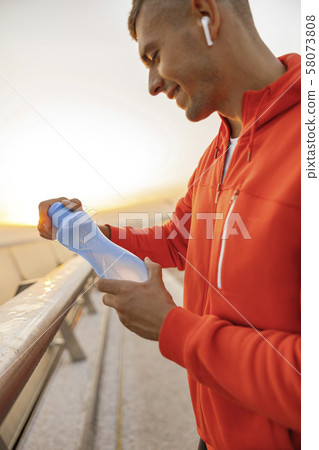 Happy cute athlete holding a water bottle 58073808