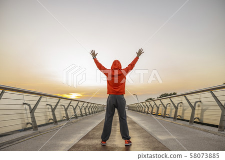 Young Caucasian sportive man warming up outdoors Young Caucasian sportive man warming up outdoors 58073885
