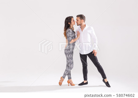 Young couple dancing latin dance bachata, merengue, salsa, kizomba. Two elegance pose over white Young couple dancing latin dance bachata, merengue, salsa, kizomba. Two elegance pose over white 58074602