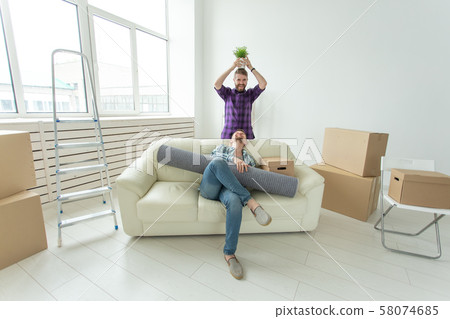 Two student male friends holding their things in their hands sitting in the living room of a new Two student male friends holding their things in their hands sitting in the living room of a new 58074685