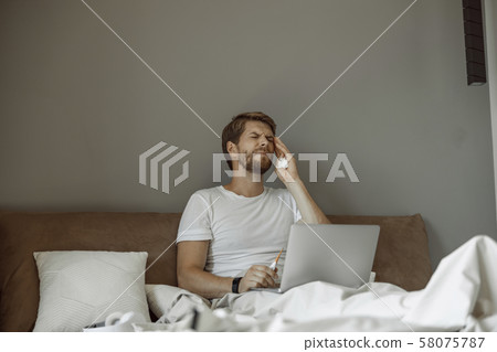 Ill young man having a racking headache 58075787