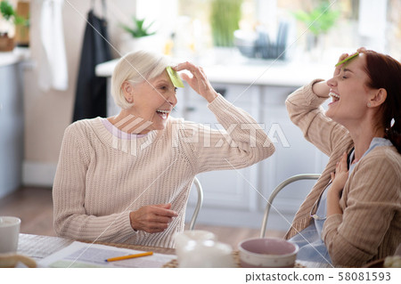 Laughing pensioner playing words game with nurse Laughing pensioner playing words game with nurse 58081593