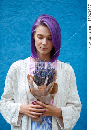 Girl with colourfull purple hair holding a lavender bouquet in her hands Girl with colourfull purple hair holding a lavender bouquet in her hands 58083697