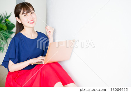 Young woman using computer in the room Young woman using computer in the room 58084435