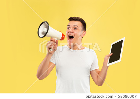 Caucasian young man's half-length portrait on yellow background Caucasian young man's half-length portrait on yellow background 58086307