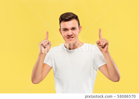 Caucasian young man's half-length portrait on yellow background Caucasian young man's half-length portrait on yellow background 58086570