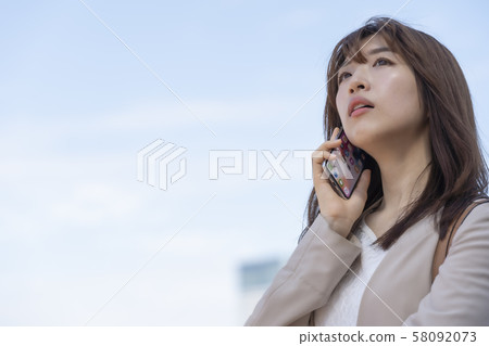 [Business] A woman who talks on a smartphone 58092073