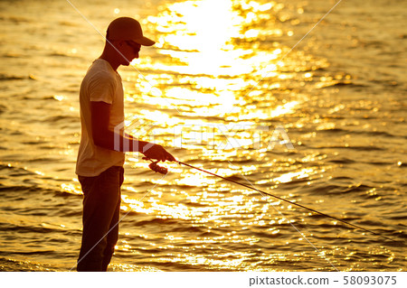 Young man fishing at sea 58093075
