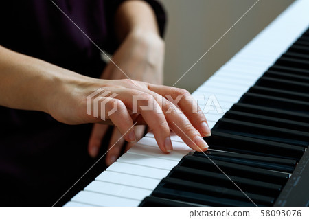 Young woman playing piano Young woman playing piano 58093076