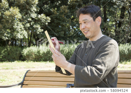 Middle-aged man singing haiku in Yoyogi Park Middle-aged man singing haiku in Yoyogi Park 58094524