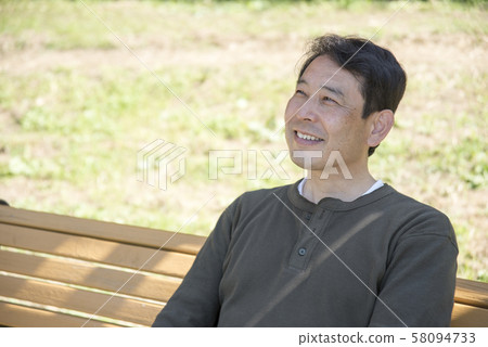 Middle-aged man relaxing on a holiday at Yoyogi Park Middle-aged man relaxing on a holiday at Yoyogi Park 58094733