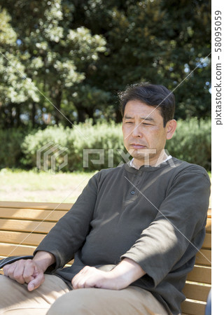 A retired middle-aged man with one person down in Yoyogi Park 58095059