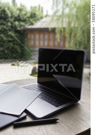 Modern laptop computer on wooden table in home 58095171