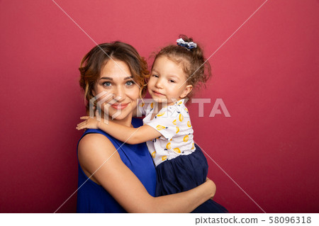 Cheerful mother and daughter smiling and having a hug. 58096318