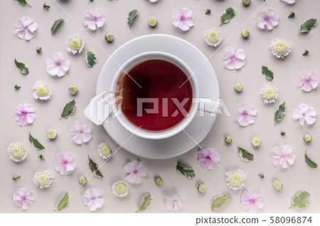 White ceramic cup with tea on a floral pattern 58096874