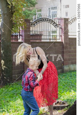 Beautiful happy young family hugs by a tree in the 58097066