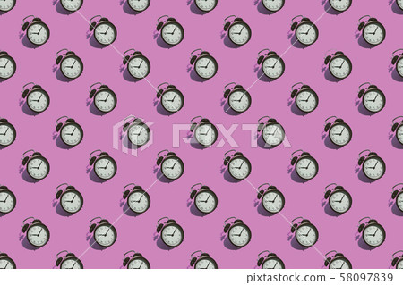 Many black classic style alarm clock isolated on pink background Many black classic style alarm clock isolated on pink background 58097839