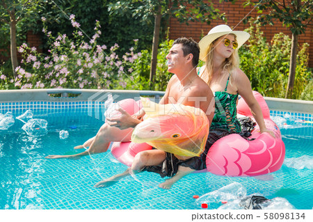 Ecology concept - Young man and woman having fun while the environment is polluted, concept of Ecology concept - Young man and woman having fun while the environment is polluted, concept of 58098134