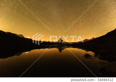Incredible night view of Stellisee lake with Matterhorn peak in Swiss Alps Incredible night view of Stellisee lake with Matterhorn peak in Swiss Alps 58098312