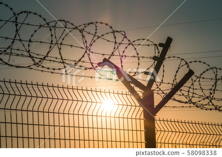 Barbed wire steel fence against the immigration in europe. Restricted area. Barbed wire steel fence against the immigration in europe. Restricted area. 58098338