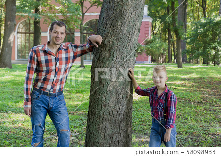 Beautiful dad and son are walking in the park. 58098933