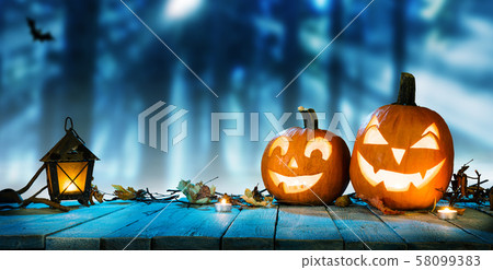 Spooky halloween pumpkins in forest 58099383