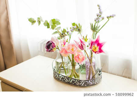 View of bouquets of tulips in glass jars View of bouquets of tulips in glass jars 58099962