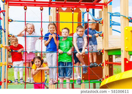 Children at school yard playground climbing together 58100611