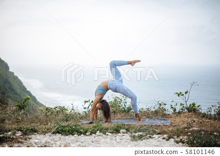 Girl practice yoga near ocean. Girl practice yoga near ocean. 58101146