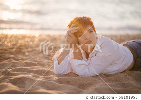 Woman with short hair on beach at sunset 58101953