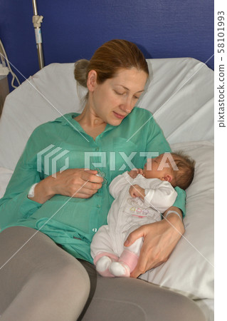 A mother looks at her newborn baby 58101993