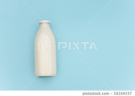 Milk in glass bottle on blue background with copy Milk in glass bottle on blue background with copy 58104337