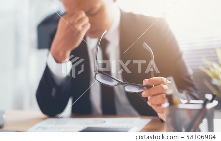 Businessman hand touching on eyes due to tiredness Businessman hand touching on eyes due to tiredness 58106984