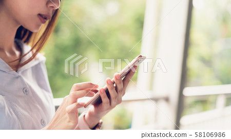 Woman using smartphone, During leisure time. Woman using smartphone, During leisure time. 58106986