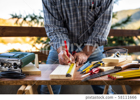 Craftsman at work on wooden boards. Carpentry. 58111666