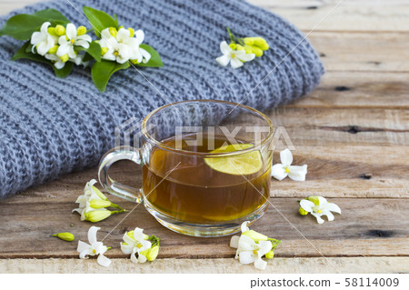 herbal healthy drinks hot lemon tea health care for cough sore with lemon slice ,jasmine flowers and knitting wool scarf of lifestyle woman relax winter herbal healthy drinks hot lemon tea health care for cough sore with lemon slice ,jasmine flowers and knitting wool scarf of lifestyle woman relax winter 58114009
