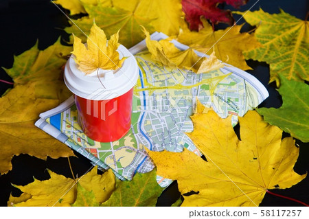 Travel in autumn. Coffee to go, leaves, map on black background Travel in autumn. Coffee to go, leaves, map on black background 58117257