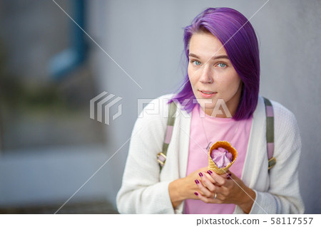 Female with violet hair holding in her hands purple ice cream 58117557