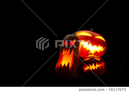 Photo of three halloween pumpkins with burning mouths on empty black background in studio. Photo of three halloween pumpkins with burning mouths on empty black background in studio. 58117673