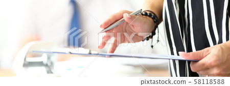 Female clerk holding in arms silver pen and application form 58118588