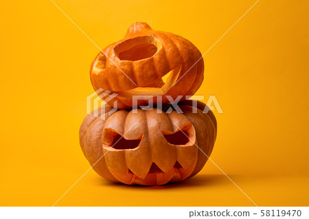 Photo of two halloween pumpkins on empty orange background 58119470