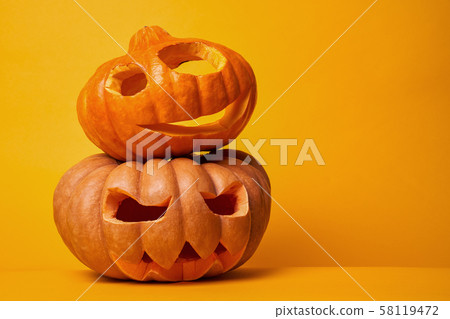 Photo of two halloween pumpkins on empty orange background Photo of two halloween pumpkins on empty orange background 58119472