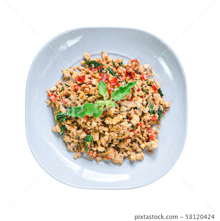 stir fried pork and basil in dish. 58120424