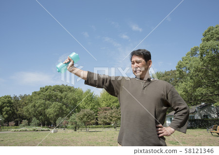 Middle-aged men doing muscle training with dumbbells in Yoyogi Park 58121346