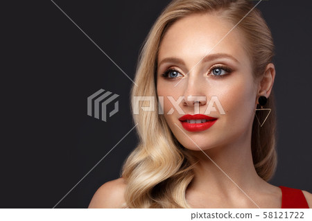 Beautiful blonde in a Hollywood manner with curls, natural makeup and red lips. Beauty face and hair 58121722