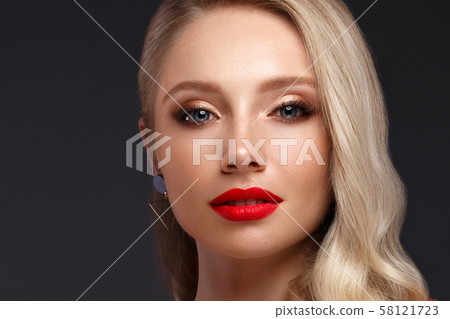 Beautiful blonde in a Hollywood manner with curls, natural makeup and red lips. Beauty face and hair 58121723