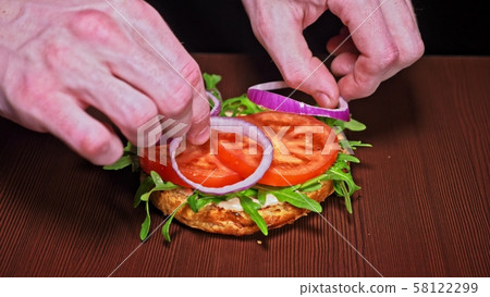 Craft burger is cooking on black background. Consist: sauce, arugula, tomato, onion, bacon, currant Craft burger is cooking on black background. Consist: sauce, arugula, tomato, onion, bacon, currant 58122299