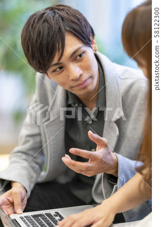 輕輕地向初級女員工教授計算機操作的年輕男性商人 輕輕地向初級女員工教授計算機操作的年輕男性商人 58122300
